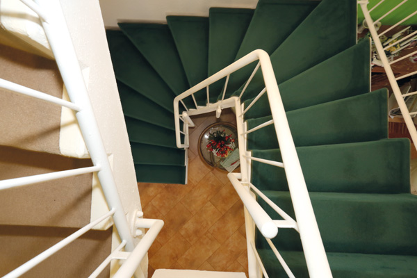 Alte Treppe mit grünem Teppichbelag vor der Renovierung